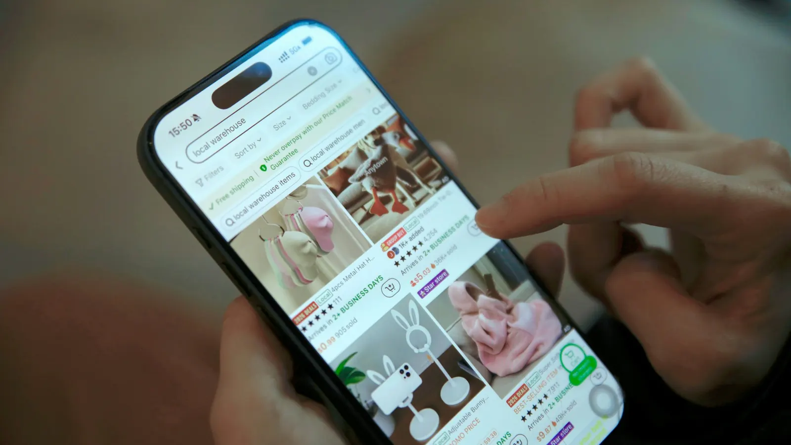 Thumbs scrolling a list of products on an iPhone screen